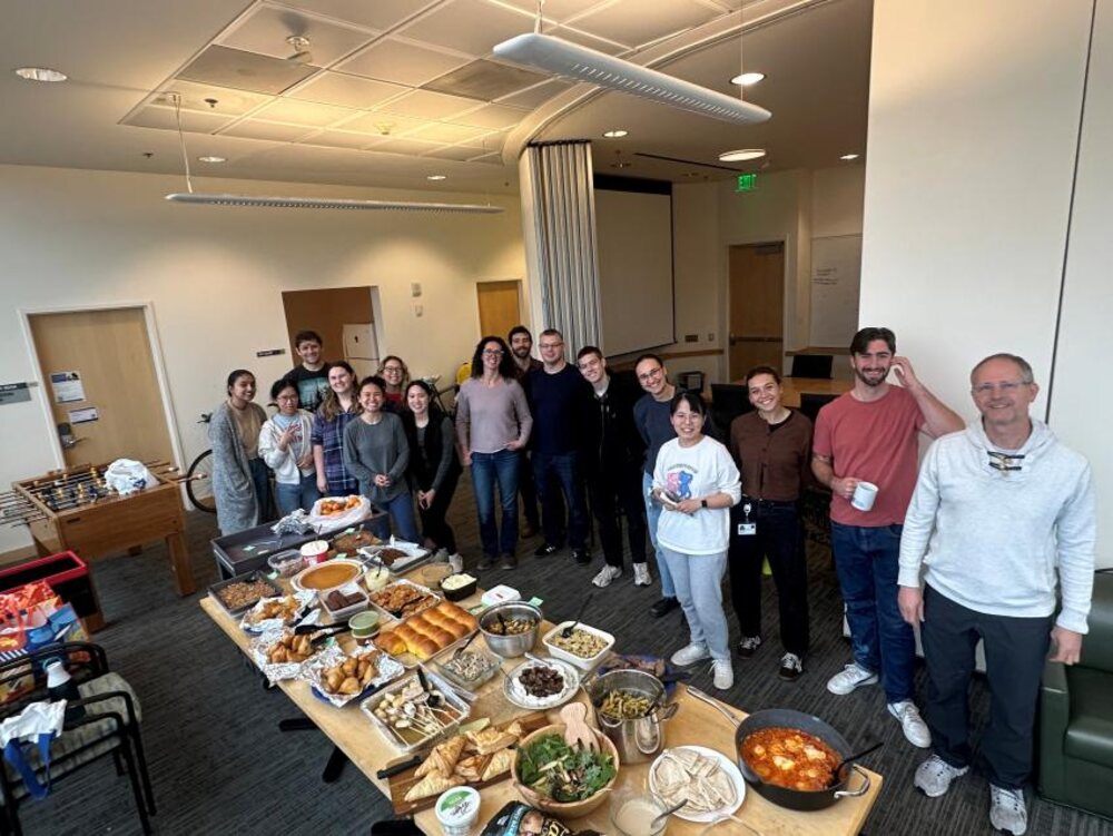 The Nadav Ahituv Lab at UCSF gathered behind a potluck table for their annual Labsgiving
