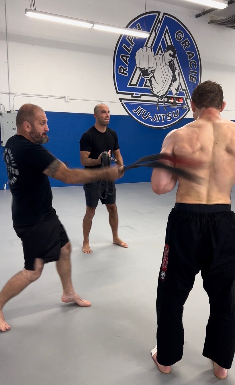 Orry Elor (back turned) receiving his purple belt from Ralph Gracie at the Ralph Gracie academy in San Francisco